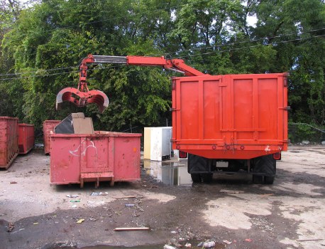 Customer pointing to a delivered skip beside a driveway